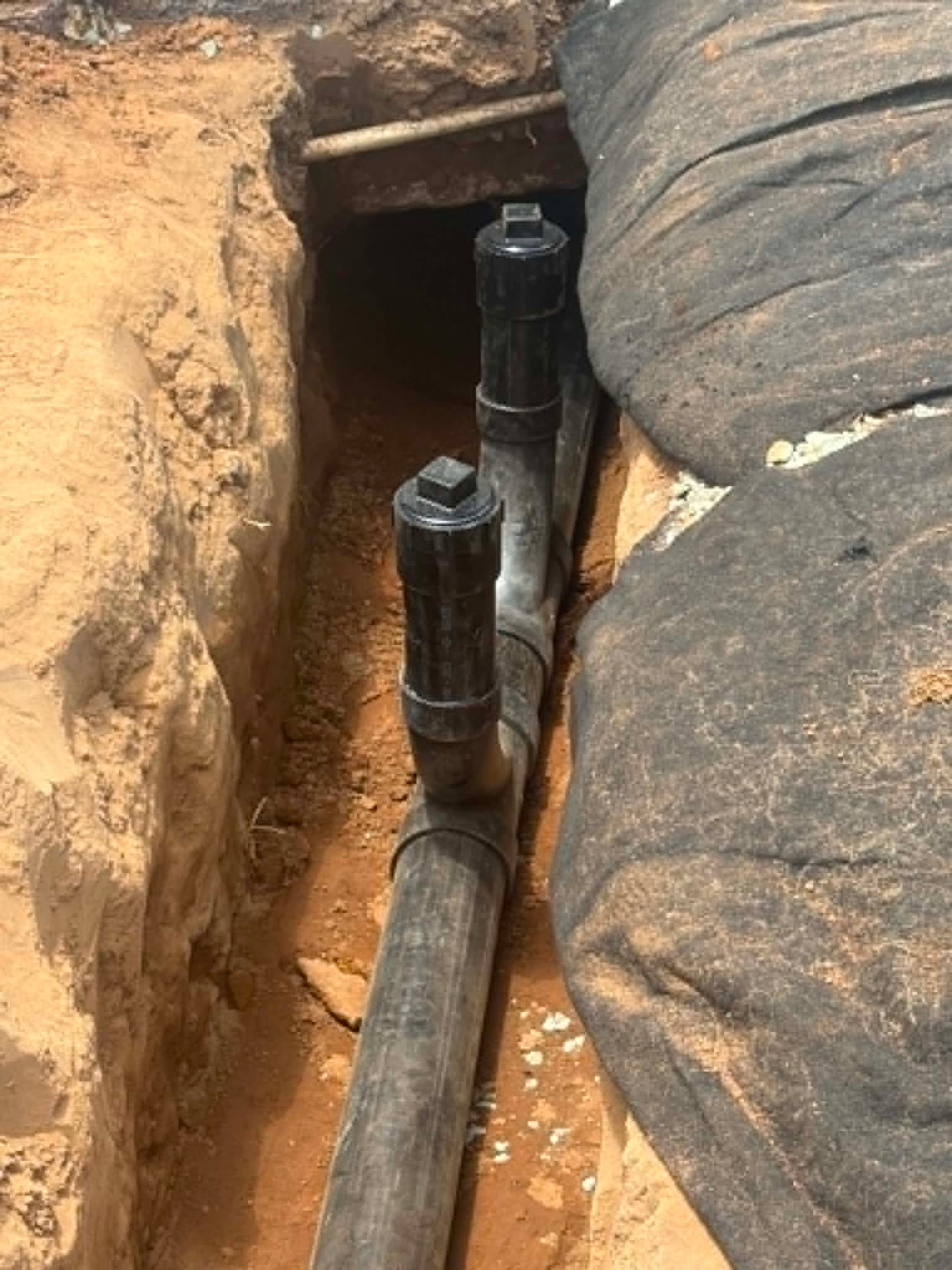 New sewer line with cleanout risers set in an open trench
